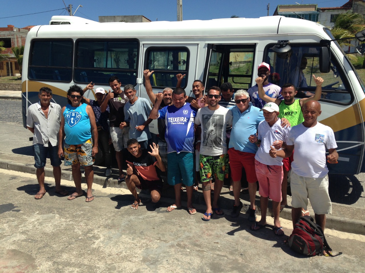 Pessoas posando pra foto em frente a ônibus